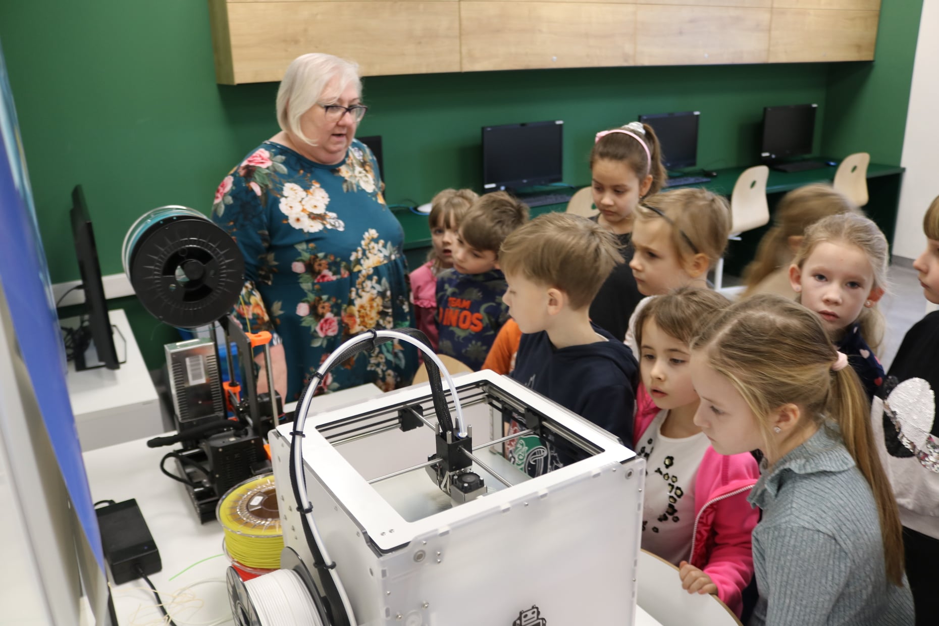 Dzieci oglądające prace drukarek 3D w pracowni robotyki